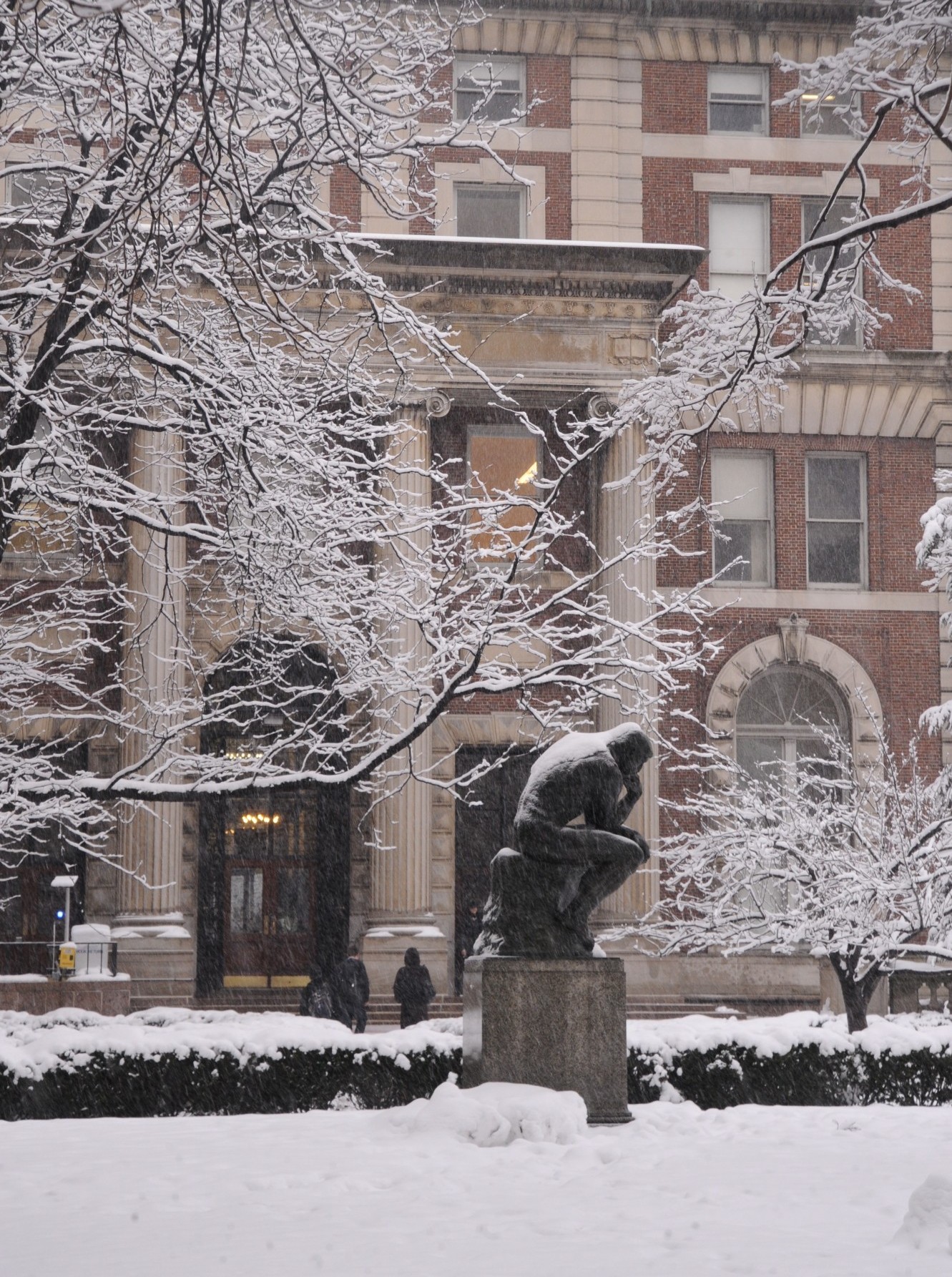 Winter scene with The Thinker (Le Penseur) by the French sculptor Auguste Rodin (1840-1917) in foreground with Kent Hall in background 