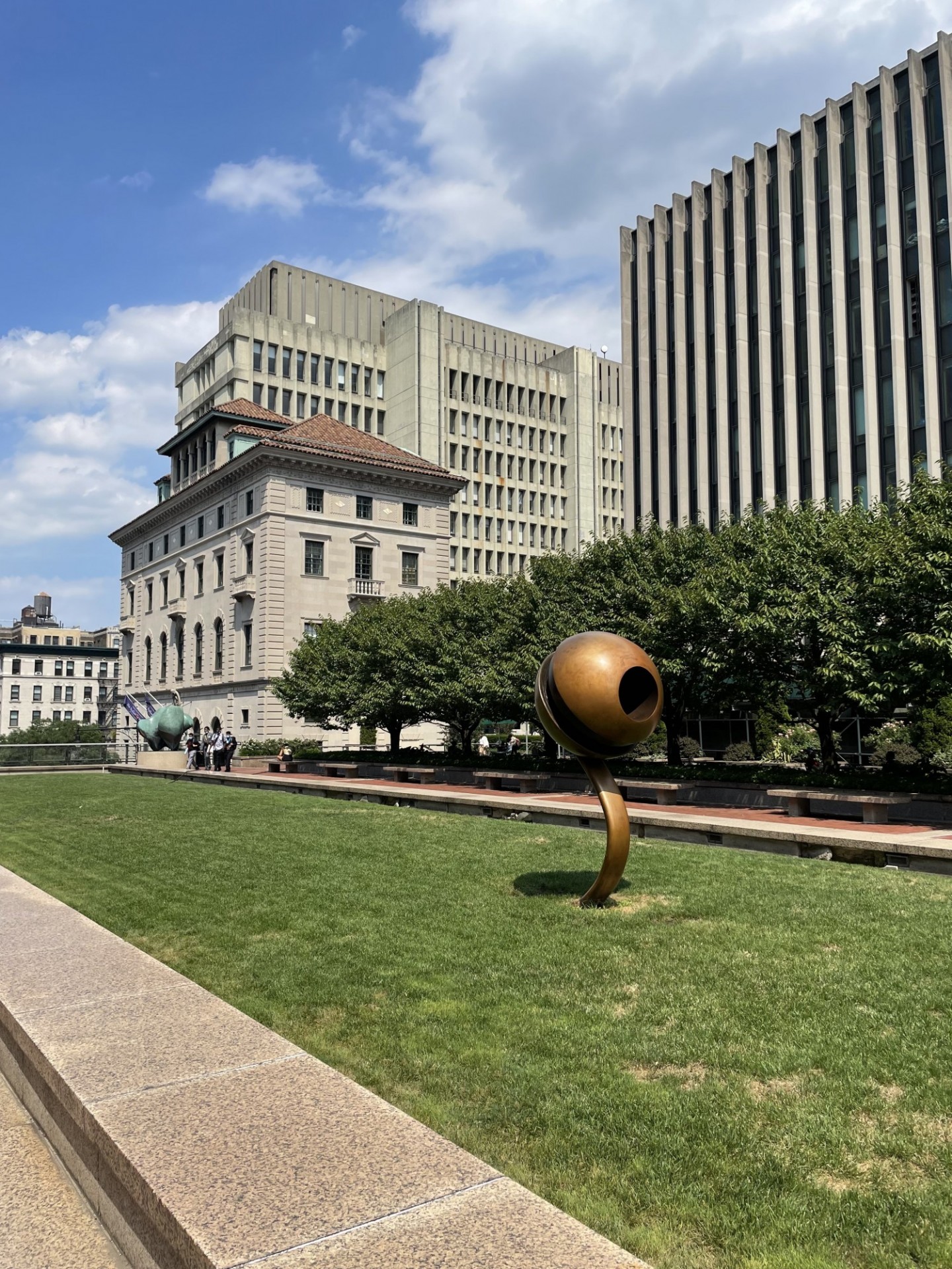 View of Revson Plaza in summer with the sculpture "Life Force," by David Bakalar in foreground